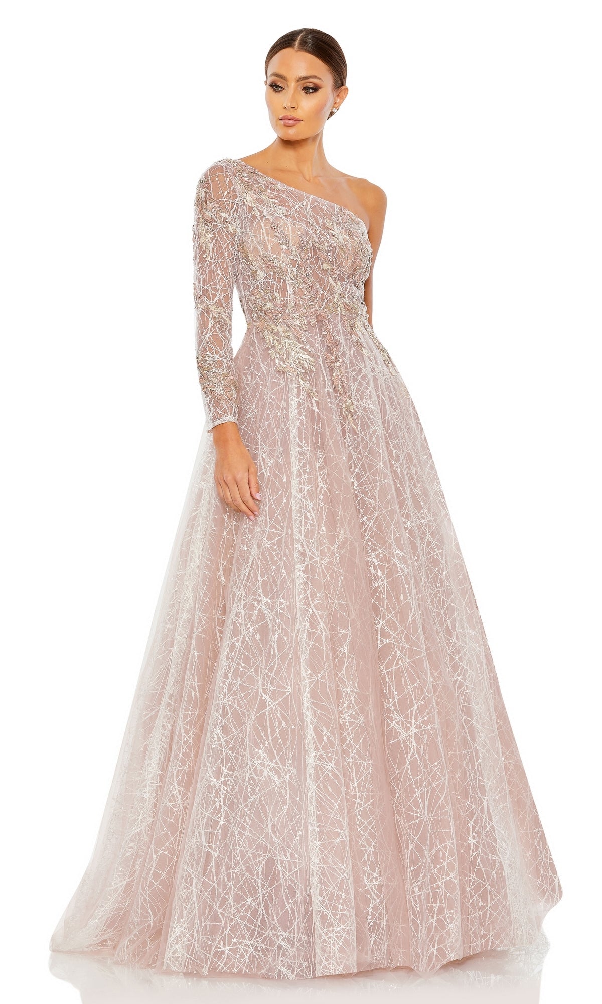 A woman poses in the Long Formal Dress 20232 by Mac Duggal, a blush pink one-shoulder ball gown with silver sequin accents, a sheer illusion bodice, and a full tulle skirt, set against a white background.
